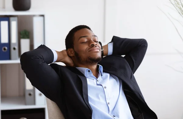 Primer plano del relajado hombre de negocios afroamericano descansando en el cargo —  Fotos de Stock