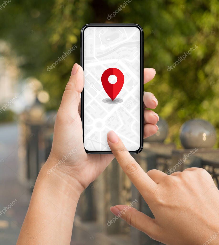 Woman tourist using navigation app on smartphone with red pinpoint on screen