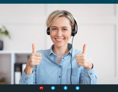 Kulaklıklı genç bir kadın ekranda gülümsüyor ve baş parmak işareti yapıyor. Video görüşmesi yapıyor, internette sohbet ediyor.