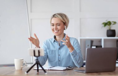 Covid-19 tecrit sırasında çevrimiçi eğitim. Genç öğretmen öğrencileri çevrimiçi eğitiyor, akıllı telefon üzerine uzaktan eğitim veriyor.