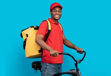 Stüdyoda bisiklete binen gülen teslimatçı.