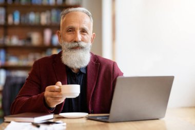 Yakışıklı yaşlı adam cafede vakit geçiriyor.