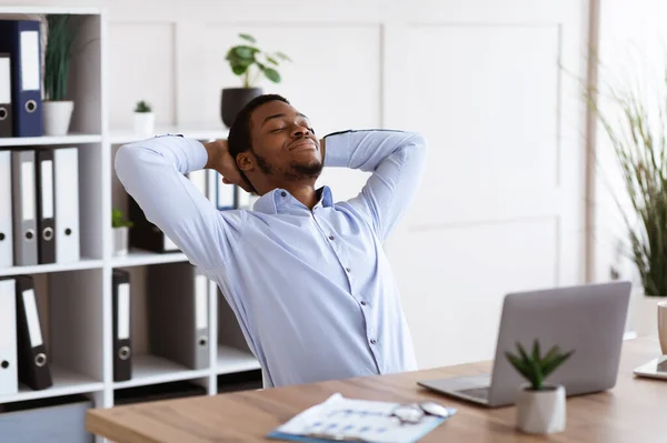Ontspannen Afrikaans-Amerikaanse manager rustend op zijn stoel — Stockfoto