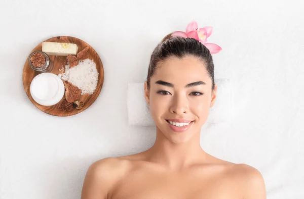 Atraente mulher asiática tendo sessão de aromaterapia com cosméticos naturais no salão de spa — Fotografia de Stock