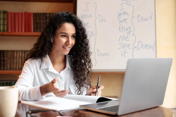 Englischlehrer sitzt am Schreibtisch und erklärt Schülern den Unterricht — Stockfoto