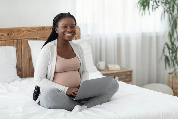 Online Θέσεις εργασίας για έγκυες γυναίκες. Μαύρη προσδοκώμενη μητέρα χρησιμοποιώντας το lap-top στο σπίτι — Φωτογραφία Αρχείου