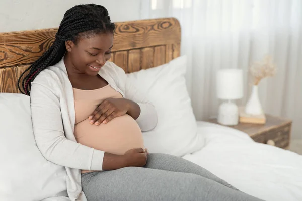 Šťastné očekávání. Portrét mladé těhotné afroamerické dámy relaxující doma — Stock fotografie