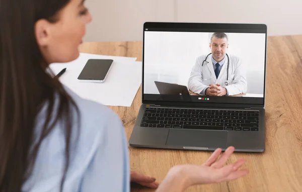 Кибермедицина. Женщина пациент чата с врачом онлайн с помощью ноутбука, имеющие видео-звонок с практикующим врачом — стоковое фото