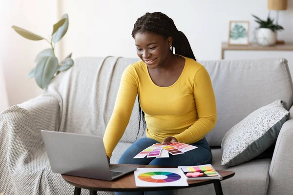 Donna nera interior designer che lavora con campioni di colore e laptop a casa — Foto Stock