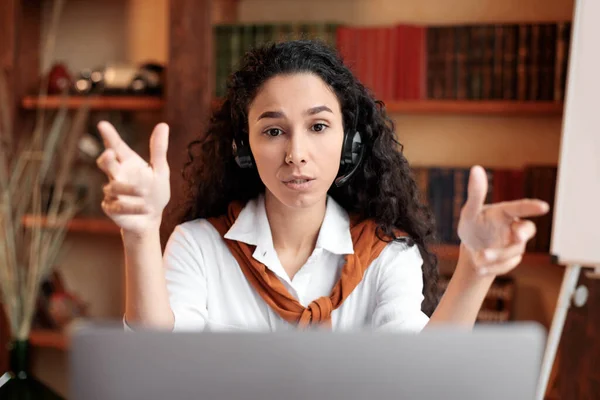 Frau sitzt am Schreibtisch und hat Videoanruf am Laptop — Stockfoto