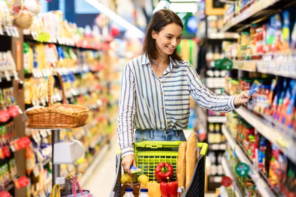 Young woman with the cart shopping in grocery store — Stock Photo, Image