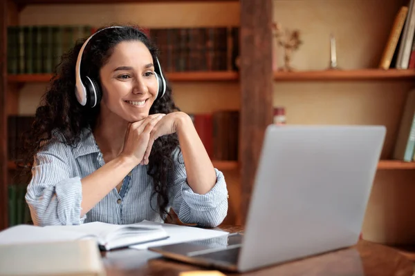 Frau sitzt am Schreibtisch und nutzt Computer mit Videoanruf — Stockfoto