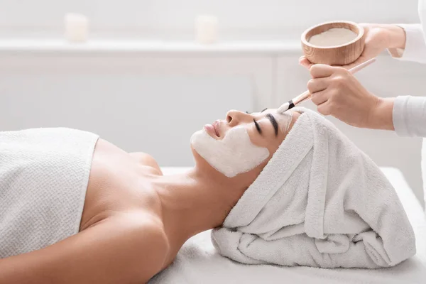 Ázsiai nő kap bőrkezelés spa, kozmetikus alkalmazó agyag arc maszk — Stock Fotó