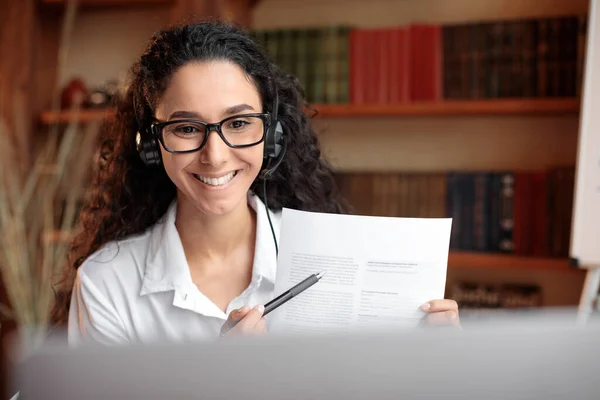 Frau mit Brille sitzt am Schreibtisch und hat Videotelefonie am Laptop — Stockfoto