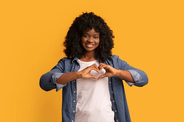 Linda senhora afro-americana mostrando símbolo do coração — Fotografia de Stock