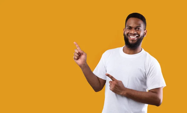 Vidám afrikai férfi ujjal mutogató felett álló sárga háttér — Stock Fotó