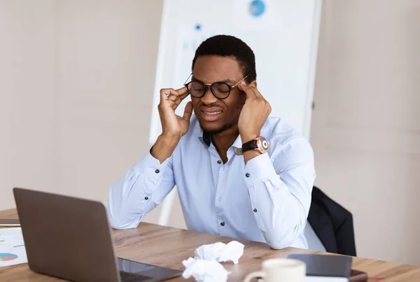 Uitgeputte zwarte manager heeft hoofdpijn tijdens het werk in het kantoor — Stockfoto