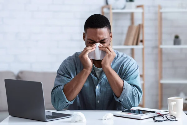 Malade noir gars souffler nez dans serviette de travail dans le bureau — Photo