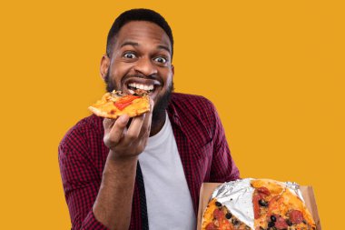 Stüdyoda pizza yiyen komik siyah adamın portresi