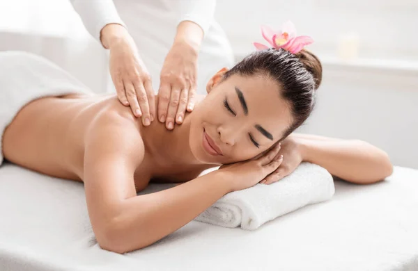 Wellness koncept. Atraktivní asijské ženy relaxační během thajské masáže sezení v salonu — Stock fotografie