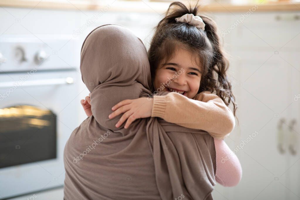Cute Little Girl Hugging Her Muslim Mom In Headscarf And Smiling
