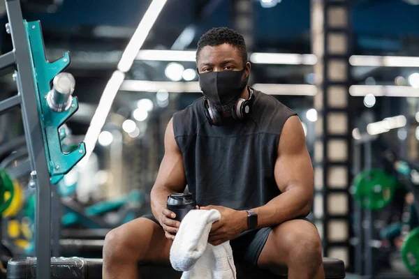 Afrikanischer Sportler mit Schutzmaske trainiert im Fitnessstudio — Stockfoto