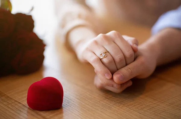 Propuesta de matrimonio. Mujer joven con anillo de compromiso, cogida de la mano con su futuro marido en la cafetería — Foto de Stock