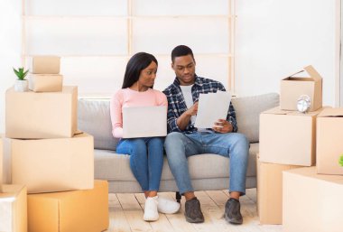 Genç siyah çift dizüstü bilgisayarda yeni evleri için tasarım projesi yapıyor.