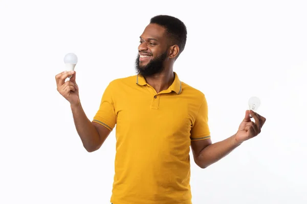 African Man Holding Two Light Bulbs Posing On White Background — Stock Photo, Image