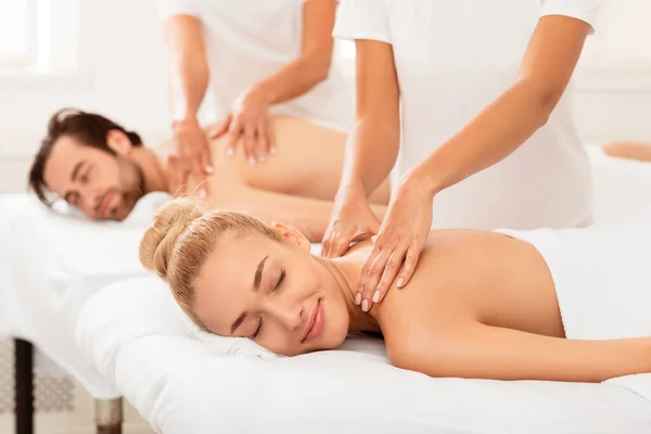 Relajado novia y novio disfrutando de masaje acostado en camas en interiores —  Fotos de Stock