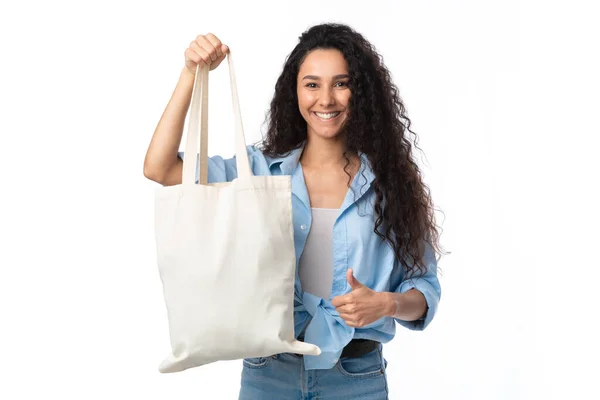 Дама показує білий еко-магазин сумка жестикулює великі пальці вгору, білий фон — стокове фото