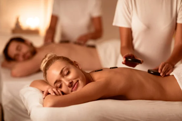 Małżonkowie otrzymujący masaż gorącymi kamieniami Relaks w luksusowym spa — Zdjęcie stockowe