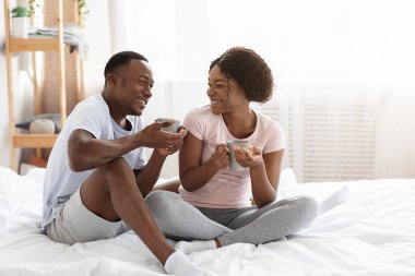 Mutlu siyah adam ve kadın evde birlikte hafta sonunun tadını çıkarıyor.