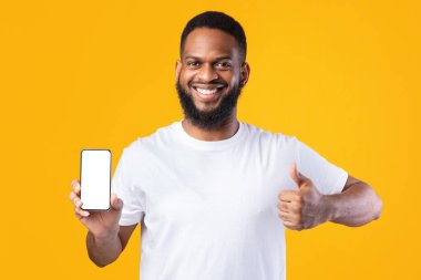 Akıllı Telefon Gösteren Afrikalı Adam Boş Ekran Hareketi Başparmaklar Yukarı, Sarı Arkaplan