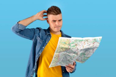 Haritayı inceleyen, kafasını kaşıyan, kendini kaybolmuş hisseden, hedefini bulmakta güçlük çeken, mavi arka plan