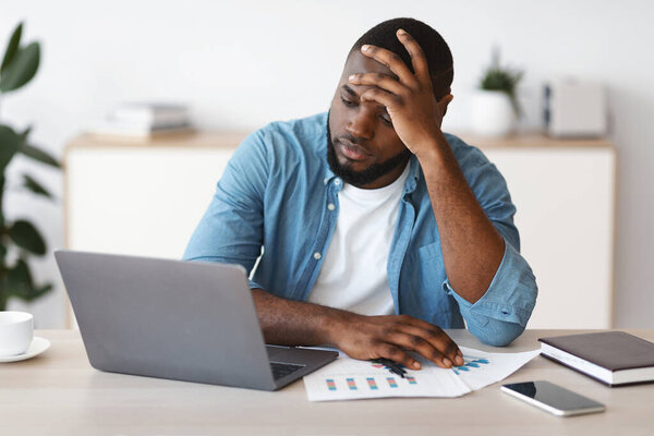 Lack Of Inspiration. Stressed Black Freelancer Guy Sitting At Desk With Laptop