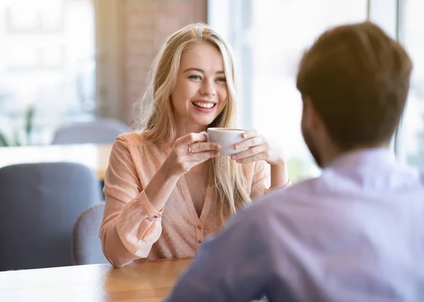 Preciosa mujer milenaria charlando con su novio en la cafetería, pasando tiempo con su amado hombre, bebiendo café —  Fotos de Stock