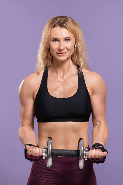 Ejercicios físicos, estilo de vida. Atractiva mujer deportista en uniforme deportivo haciendo ejercicio con mancuerna — Foto de Stock