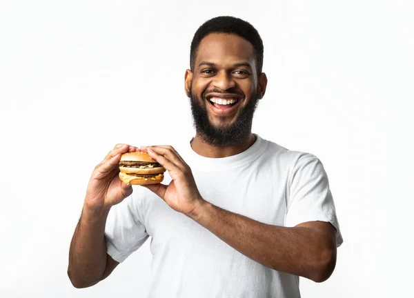Feliz afro-americano homem posando com hambúrguer, estúdio tiro — Fotografia de Stock