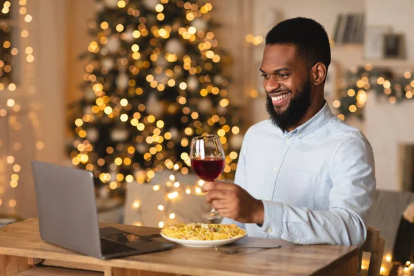 Black man having dinner during virtual date on laptop — Stock Photo, Image
