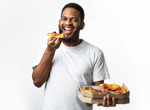 Chico negro disfrutando de la pizza posando con la caja de pizzería, Studio Shot — Foto de Stock