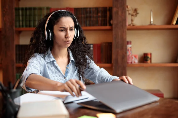 Femme fatiguée assise au bureau, fermant ou ouvrant un ordinateur portable — Photo