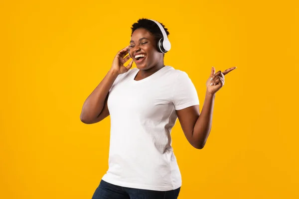 Gelukkig overgewicht zwarte dame dragen hoofdtelefoon genietend van muziek in de studio — Stockfoto