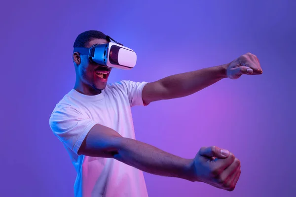 Nowoczesne gry. Czarny człowiek w okularach VR Doświadczanie wirtualnej rzeczywistości, Neon Lighting — Zdjęcie stockowe