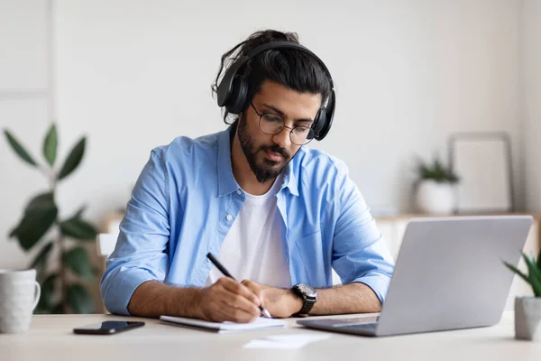 Afstandsonderwijs. Jonge Arabier in hoofdtelefoon studeren met laptop thuis — Stockfoto