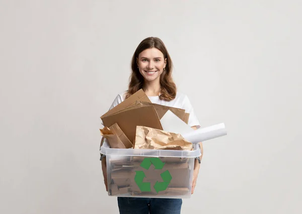 Recycling und Mülltrennung. Lächelnde Frau hält Plastikbox mit Papiermüll in der Hand — Stockfoto