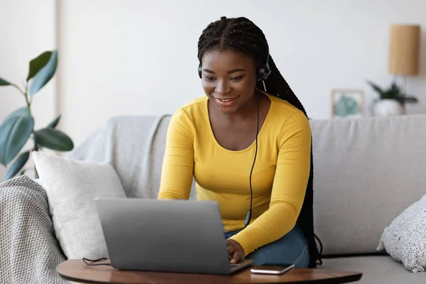 Online Education. Black Millennial Woman In Headset Studying With Laptop At Home