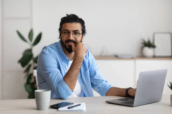 Porträt des lächelnden arabischen Freelancer Guy, der am Schreibtisch im Home Office sitzt — Stockfoto