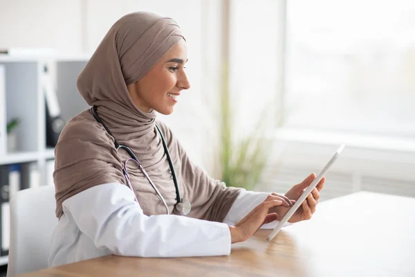 Жінка-лікар мусульманка використовує планшет Дігіта — стокове фото