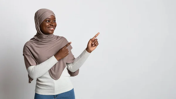 Mira allí. Feliz dama negra islámica en Hijab señalando el espacio de copia — Foto de Stock